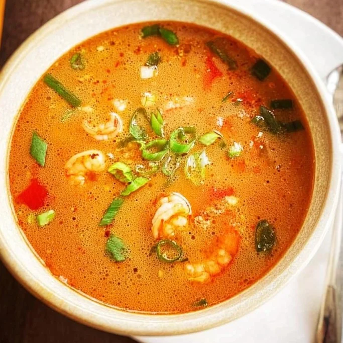 Delicious bowl of Shrimp Tom Yum soup garnished with herbs and spices
