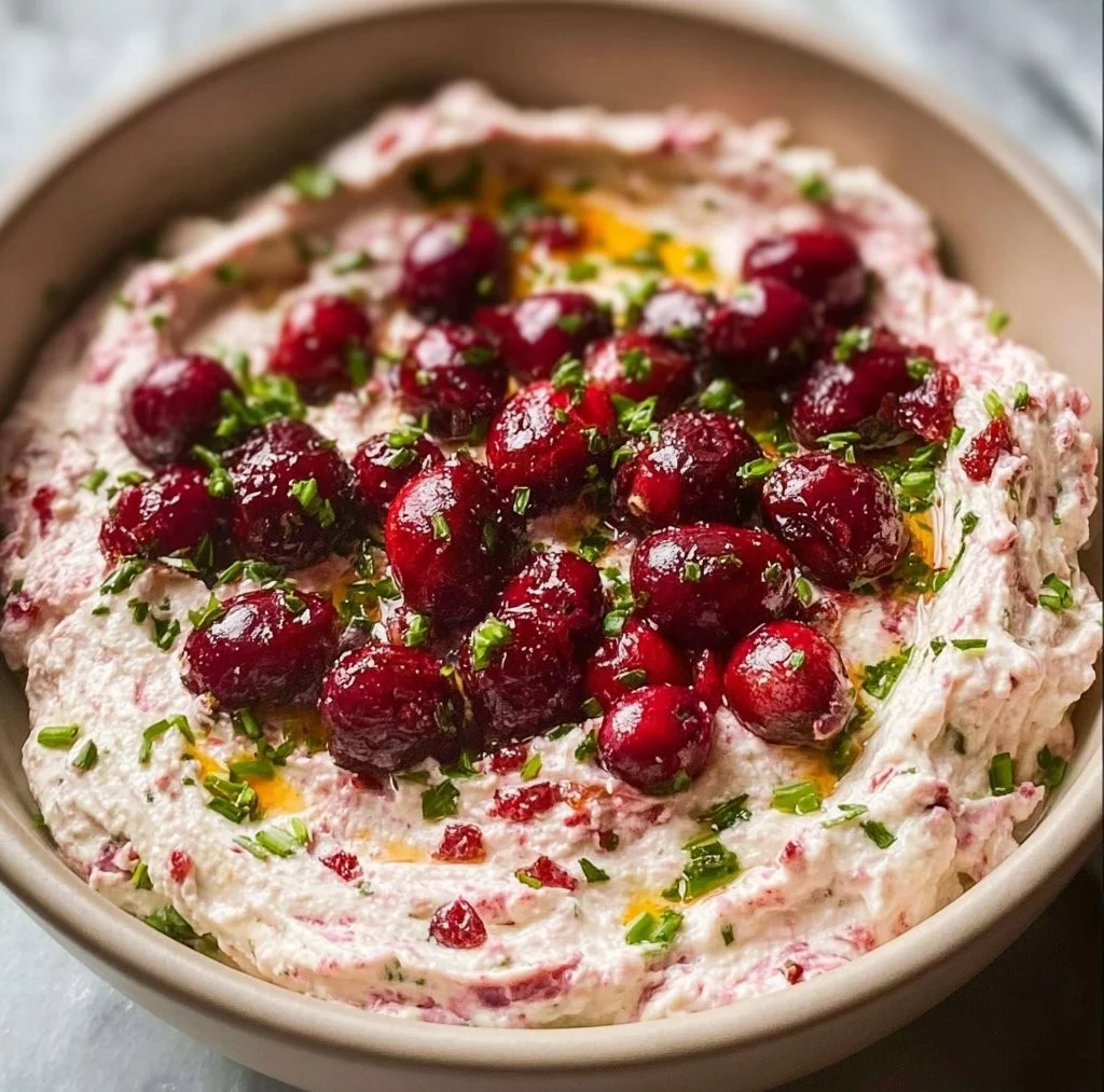Creamy Cranberry Jalapeno Dip served in a bowl, garnished with herbs