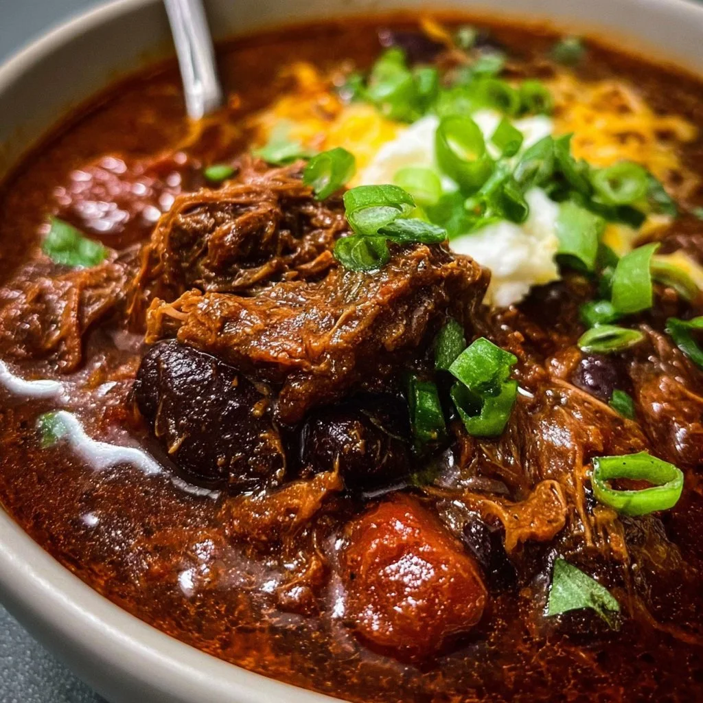 Bowl of hearty crock pot beef chuck chili with toppings