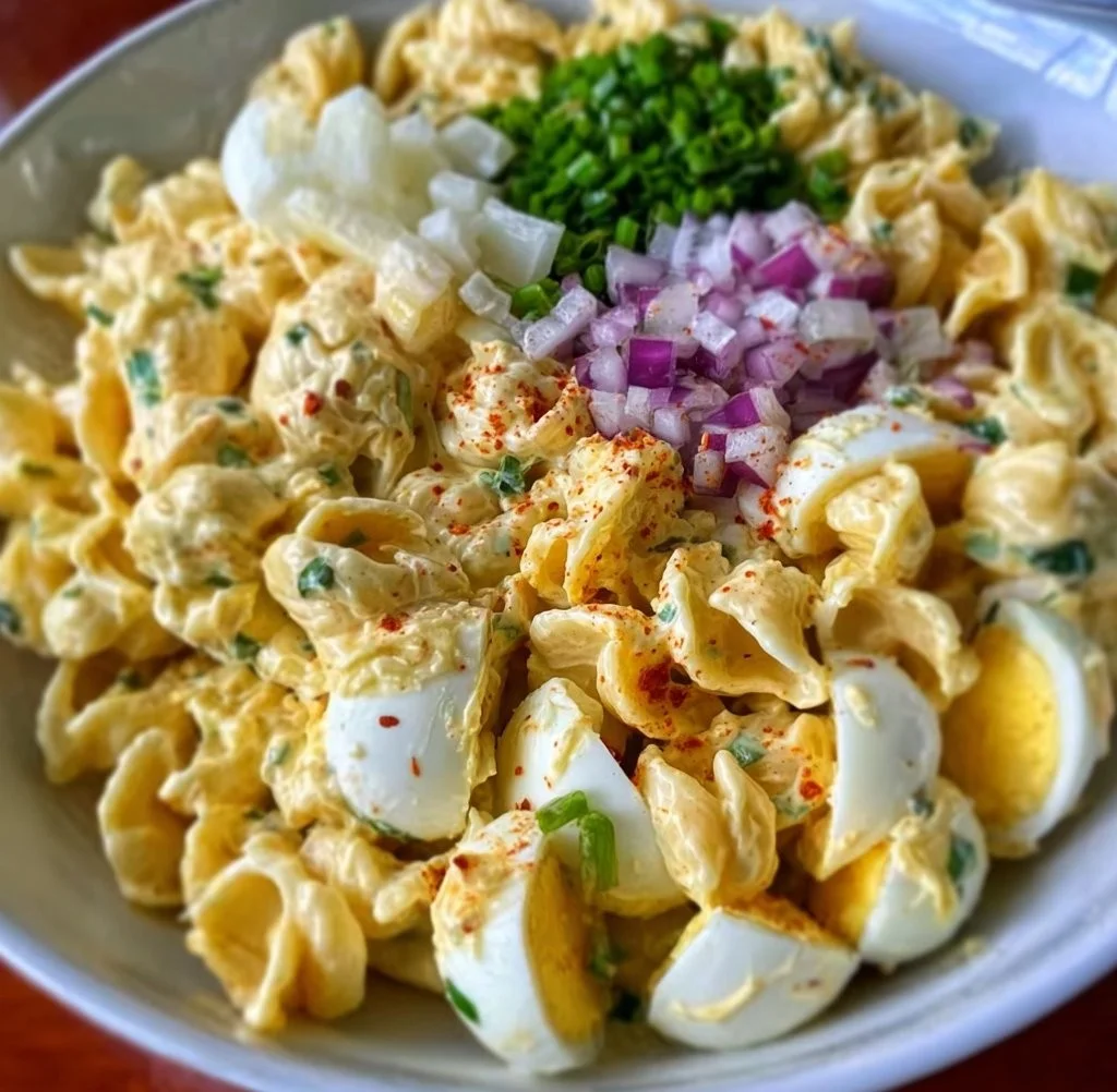 Delicious deviled egg pasta salad topped with fresh herbs and spices