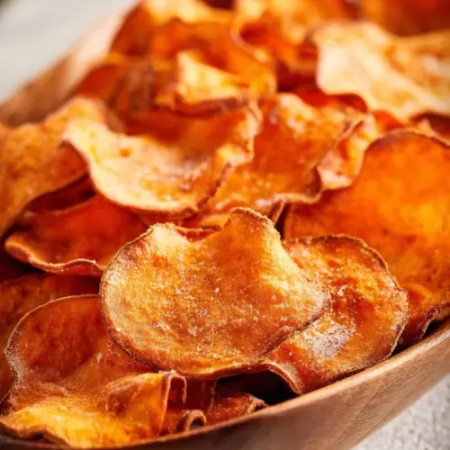Crispy air fryer sweet potato chips in a bowl, garnished and ready to eat.