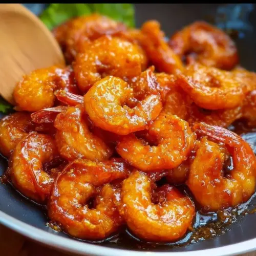 Crispy Orange Shrimp dish garnished with fresh herbs on a plate