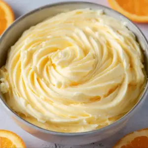 Orange cream cheese frosting swirled on a cupcake